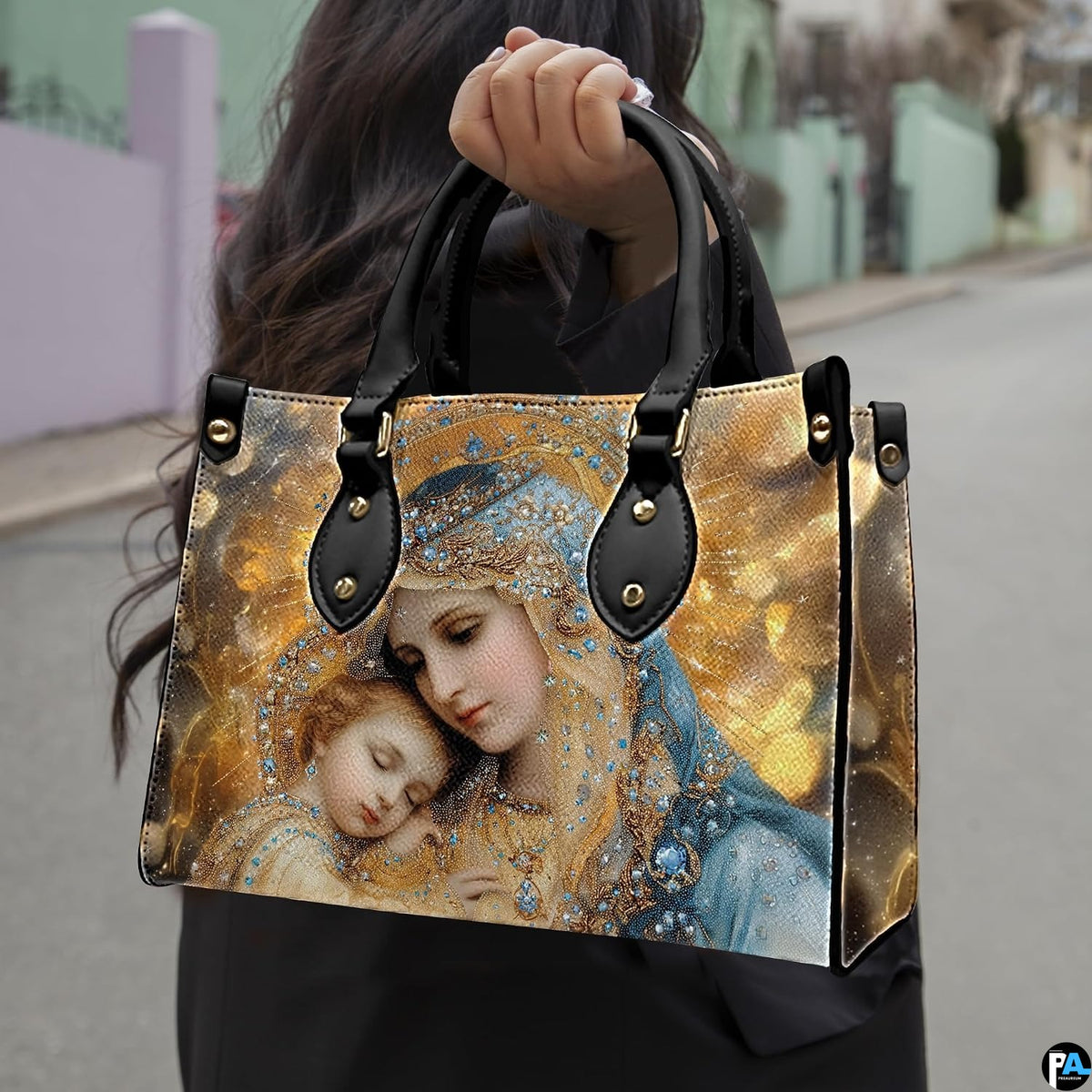 Model holding the bejeweled Virgin Mary and sleeping baby Jesus handbag outdoors on city street