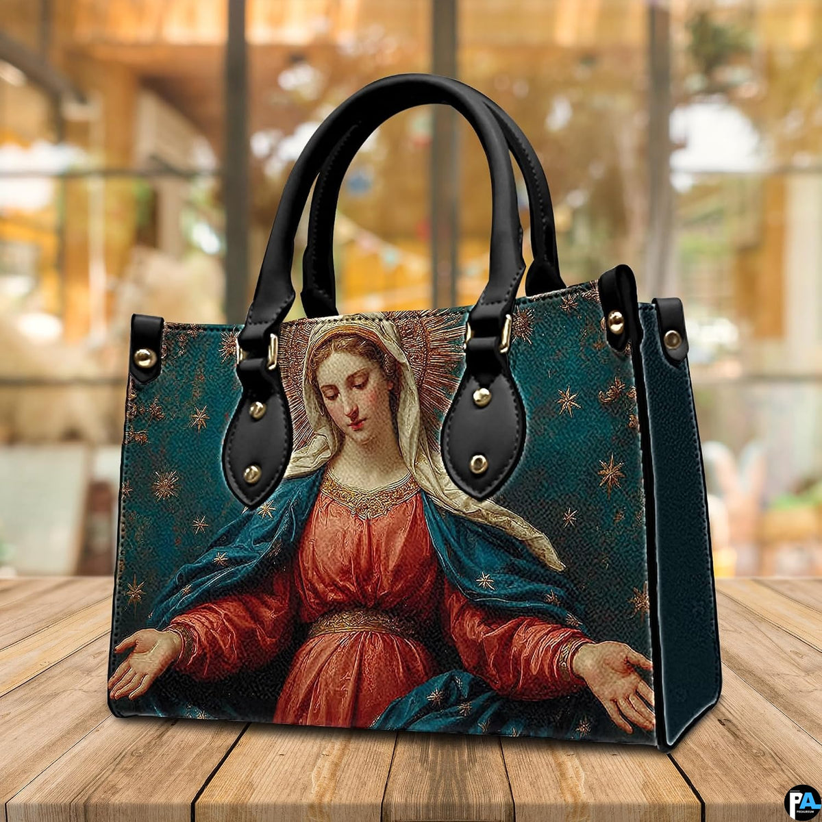 Madonna sacred art handbag displayed outdoors beside a cafe table setting