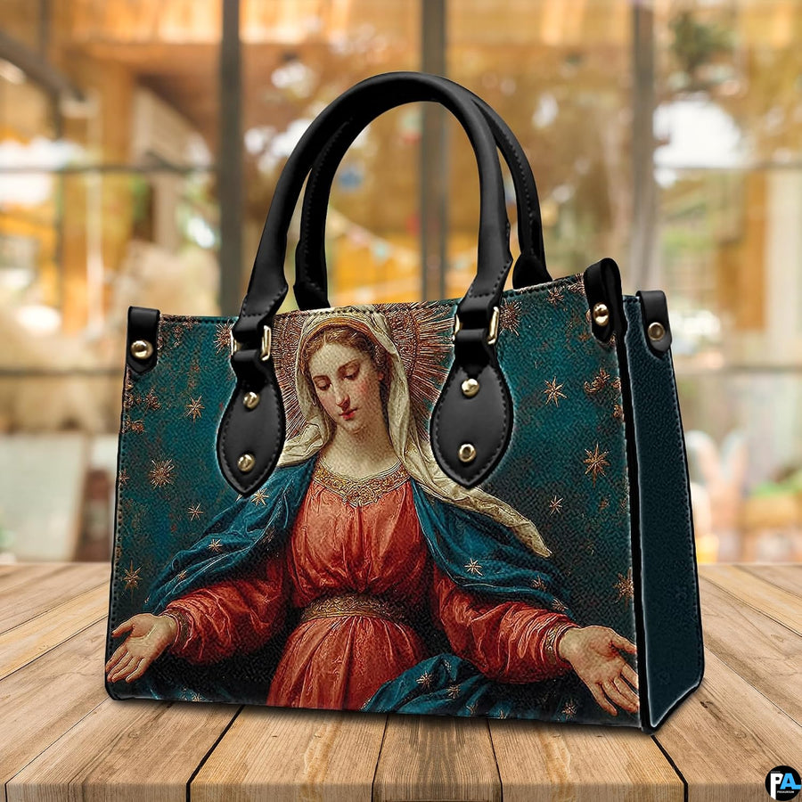 Madonna sacred art handbag displayed outdoors beside a cafe table setting