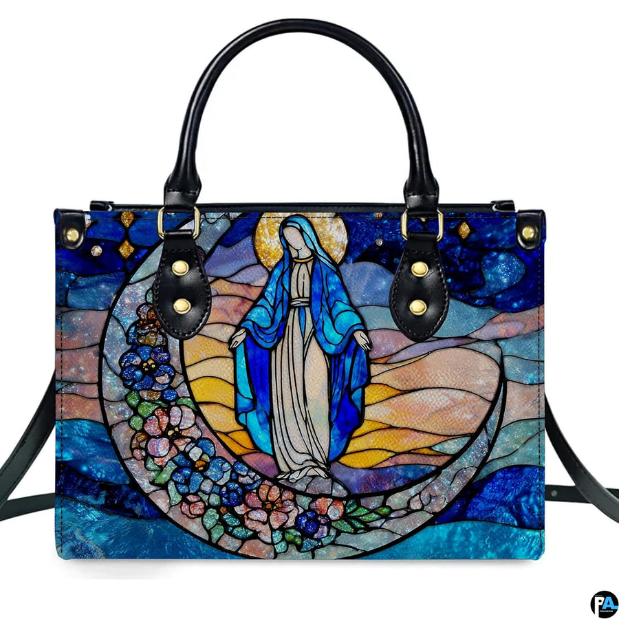 Stained glass art of the Virgin Mary on a floral crescent moon against a starry sky printed on a structured handbag.