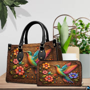 Handbag and matching wallet set displayed together on wooden table beside a green houseplant.