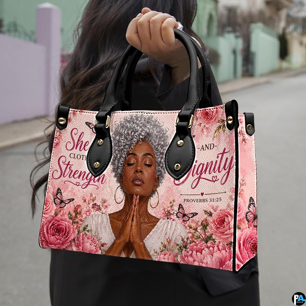 Daylight street presentation highlighting the floral faith portrait design held in natural light.