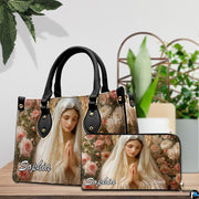 Virgin Mary floral devotional handbag and companion wallet on wooden display surface