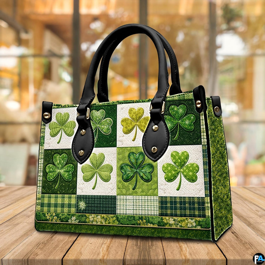 Angled view of green clover handbag with plaid band and floral borders