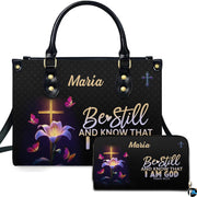 Front view of illuminated cross handbag and matching wallet featuring a blooming lily and radiant butterflies.