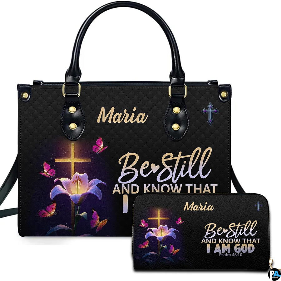 Front view of illuminated cross handbag and matching wallet featuring a blooming lily and radiant butterflies.