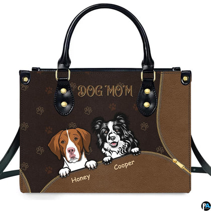 Front view of brown dog lover handbag featuring illustrated hound and border collie pups with gold paw prints.