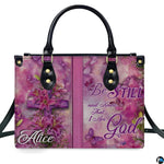 Side profile view of structured pink handbag showing sleek silhouette and black carrying handles.