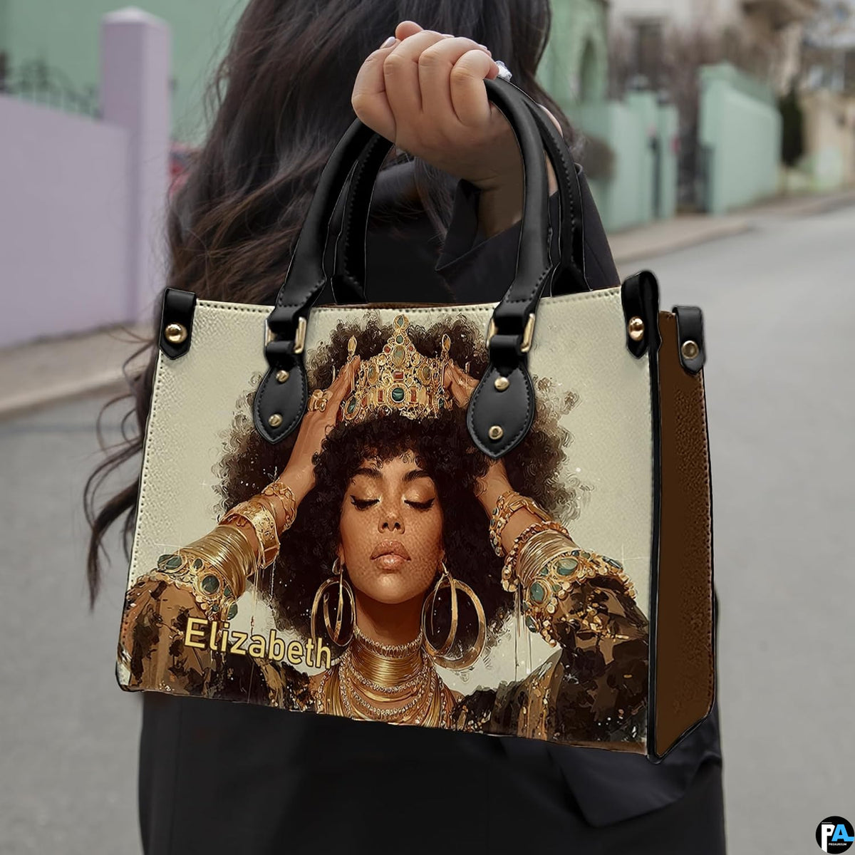 Woman carrying royal afro portrait handbag with gold crown and layered jewelry
