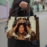 Woman carrying royal afro portrait handbag with gold crown and layered jewelry
