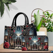 Gothic cathedral handbag and wallet set shown together on wooden tabletop next to green plant.
