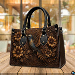 Close view of dimensional floral relief and ornate corner scrollwork on botanical handbag.
