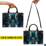 Dual display showing handheld carrying and shoulder wear for teal snowflake handbag.