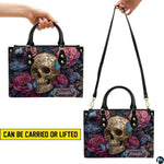 Filigree skull handbag carrying demonstration showing top handle and shoulder strap carry.