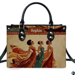 Direct studio front view of the structured handbag featuring three royal African women in ornate dresses.