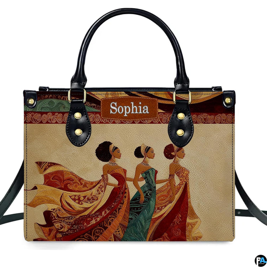 Direct studio front view of the structured handbag featuring three royal African women in ornate dresses.