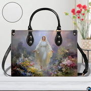 Lifestyle tabletop view of Our Lady of Grace floral handbag beside white texture swatch.