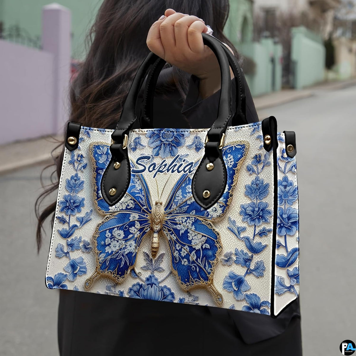 Model carrying blue porcelain butterfly handbag outdoors