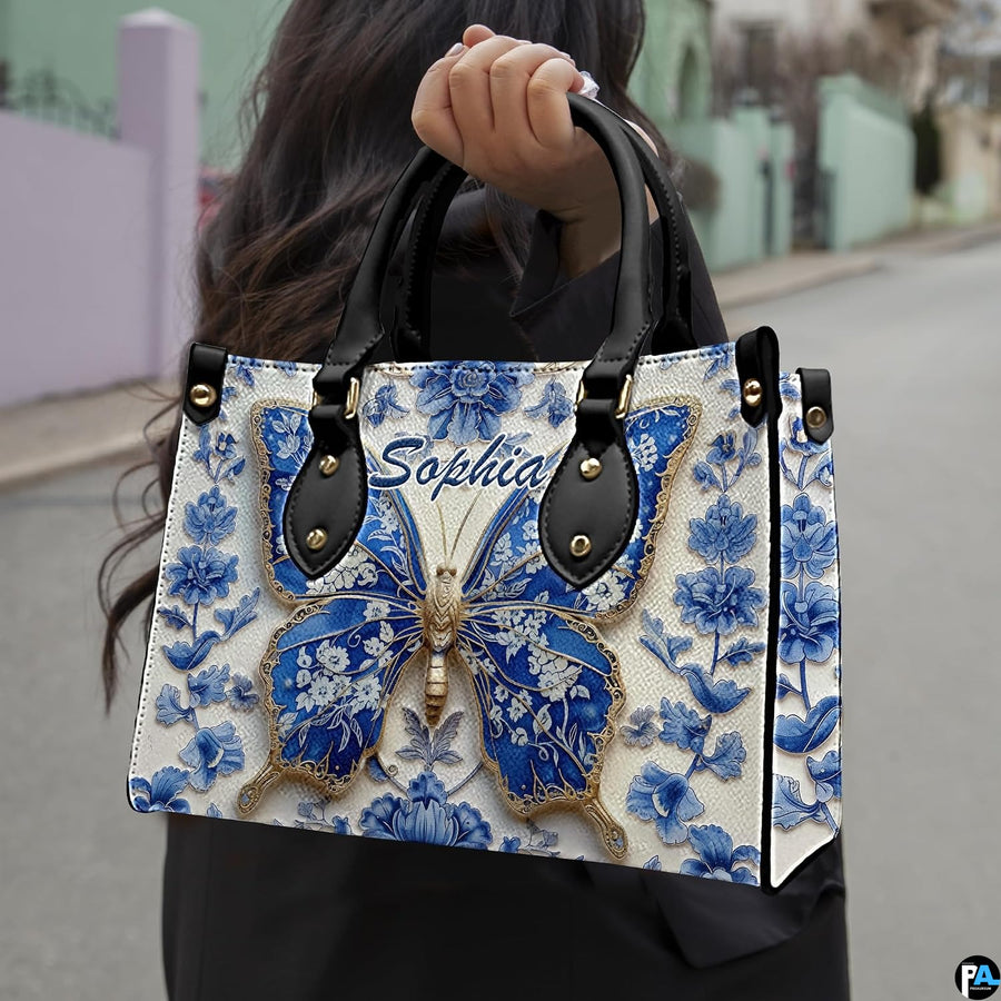 Model carrying blue porcelain butterfly handbag outdoors