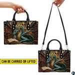 Bottom view of library dragon handbag showing protective gold base hardware
