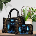 Indoor presentation of Celtic black cat artwork alongside matching companion accessory on wooden tabletop near plants.