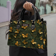 Woman carrying the forest green golden butterfly handbag outdoors on a street.