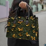 Woman carrying the forest green golden butterfly handbag outdoors on a street.
