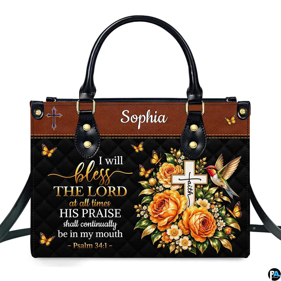 Hummingbird cross handbag and wallet displayed on wooden table beside potted plant.