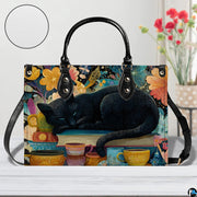 Close studio perspective of sleeping black cat art positioned on white surface beside flowers.