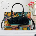 Close studio perspective of sleeping black cat art positioned on white surface beside flowers.