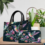 Handbag and matching wallet set displayed together on wooden table beside a green houseplant.