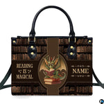 Front view of structured handbag showing green dragon with spectacles reading books against antique library backdrop