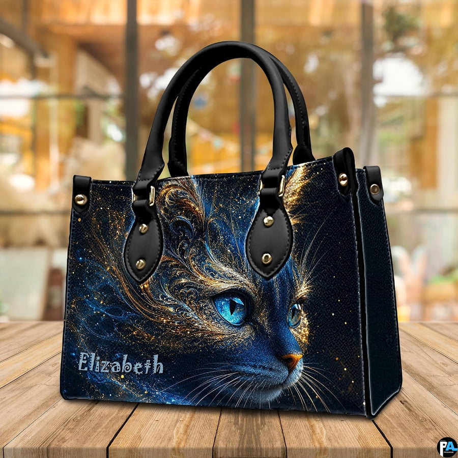 Angled tabletop view showing cosmic blue cat artwork resting near a sunlit cafe window.