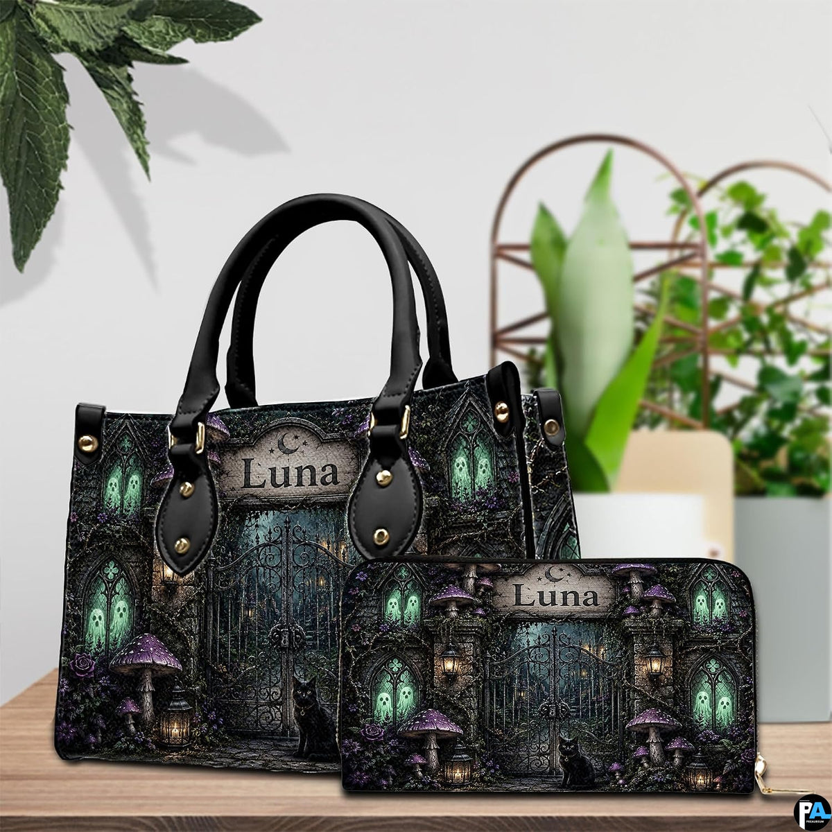 Tabletop scene showing gothic cemetery art accessory resting beside indoor potted foliage.