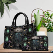 Tabletop scene showing gothic cemetery art accessory resting beside indoor potted foliage.