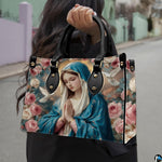 Street lifestyle view of woman carrying Virgin Mary floral devotional handbag.