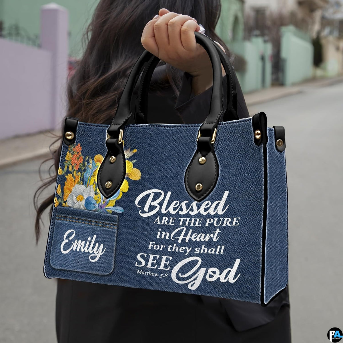 Street lifestyle view of scripture denim wildflower handbag held by hand on sidewalk