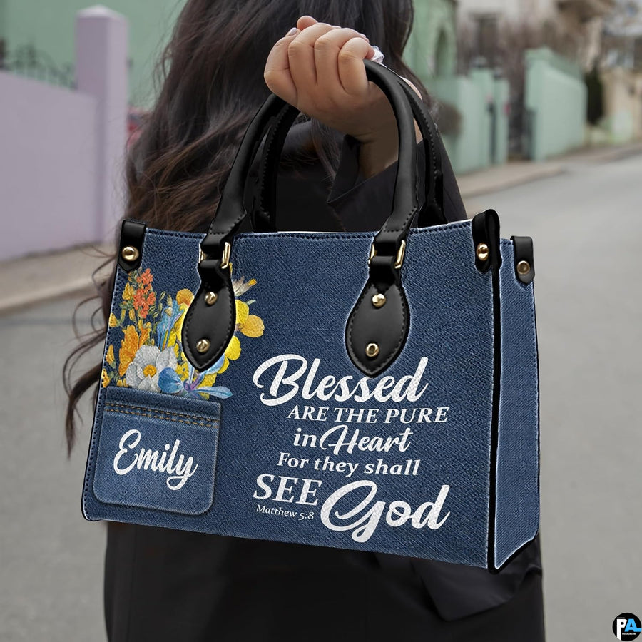 Street lifestyle view of scripture denim wildflower handbag held by hand on sidewalk