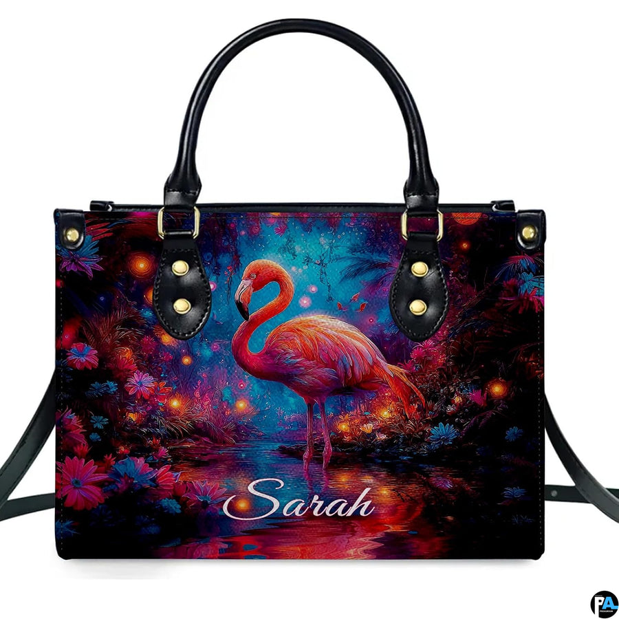 Lifestyle view of the glowing flamingo handbag on a city sidewalk.