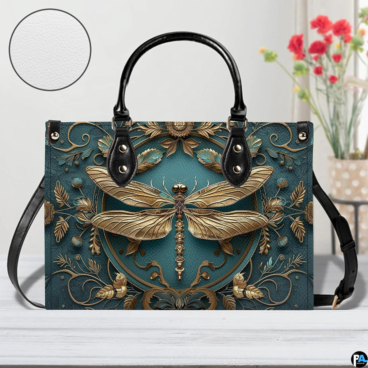 Front view of gold dragonfly handbag on white table with floral vase and texture swatch inset