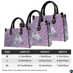 Coordinated arrangement of handbag and wallet displaying the matching unicorn design.