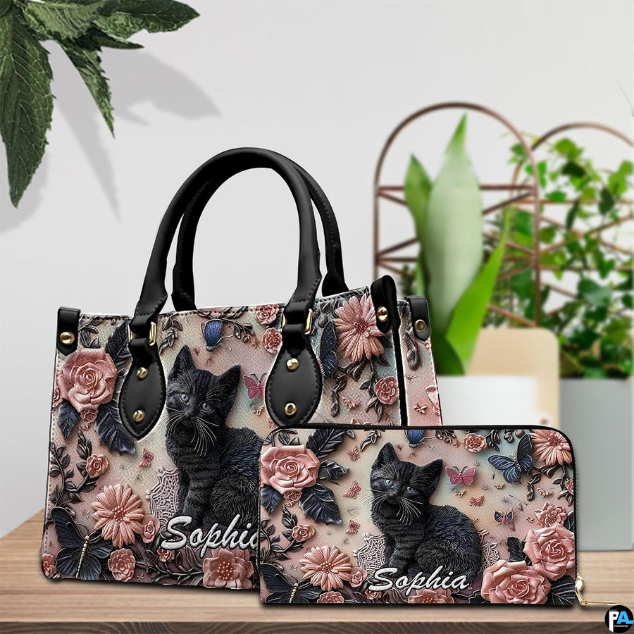 Close-up front view of handbag showing black kitten, pink roses, and butterflies