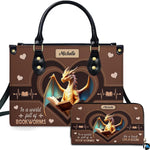 Front view of structured handbag featuring golden dragon reading inside heart frames, displayed with matching wallet