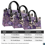 Lavender skull handbag and wallet displayed on wooden table beside potted plant.