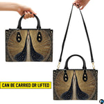 Angled perspective showing starry blue mantle Virgin Mary artwork on structured handbag