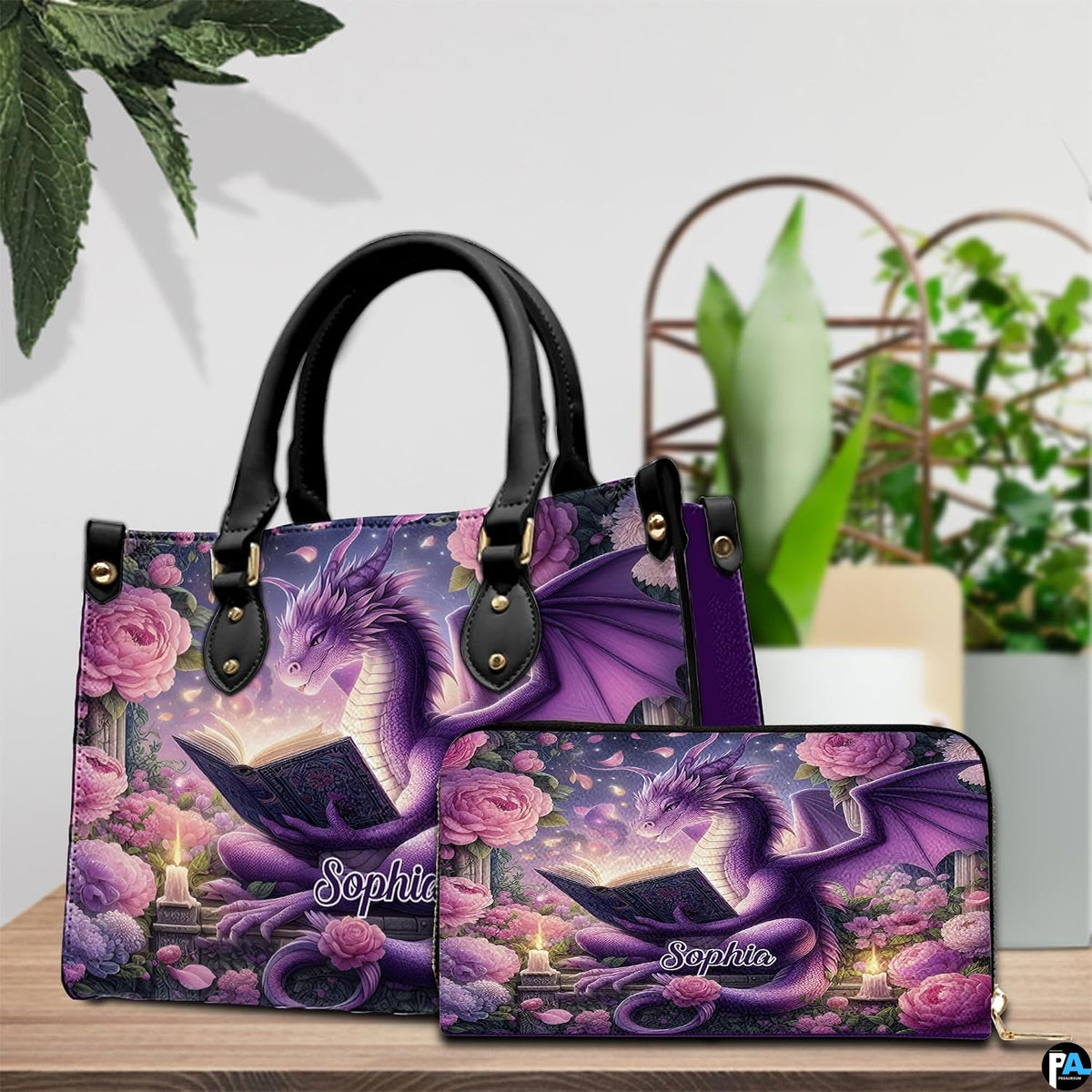 Reading dragon handbag and wallet set displayed on wooden table beside houseplant.