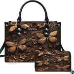 Embossed bronze dragonfly handbag and matching wallet set shown against a plain white studio background.