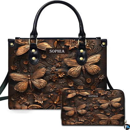 Embossed bronze dragonfly handbag and matching wallet set shown against a plain white studio background.