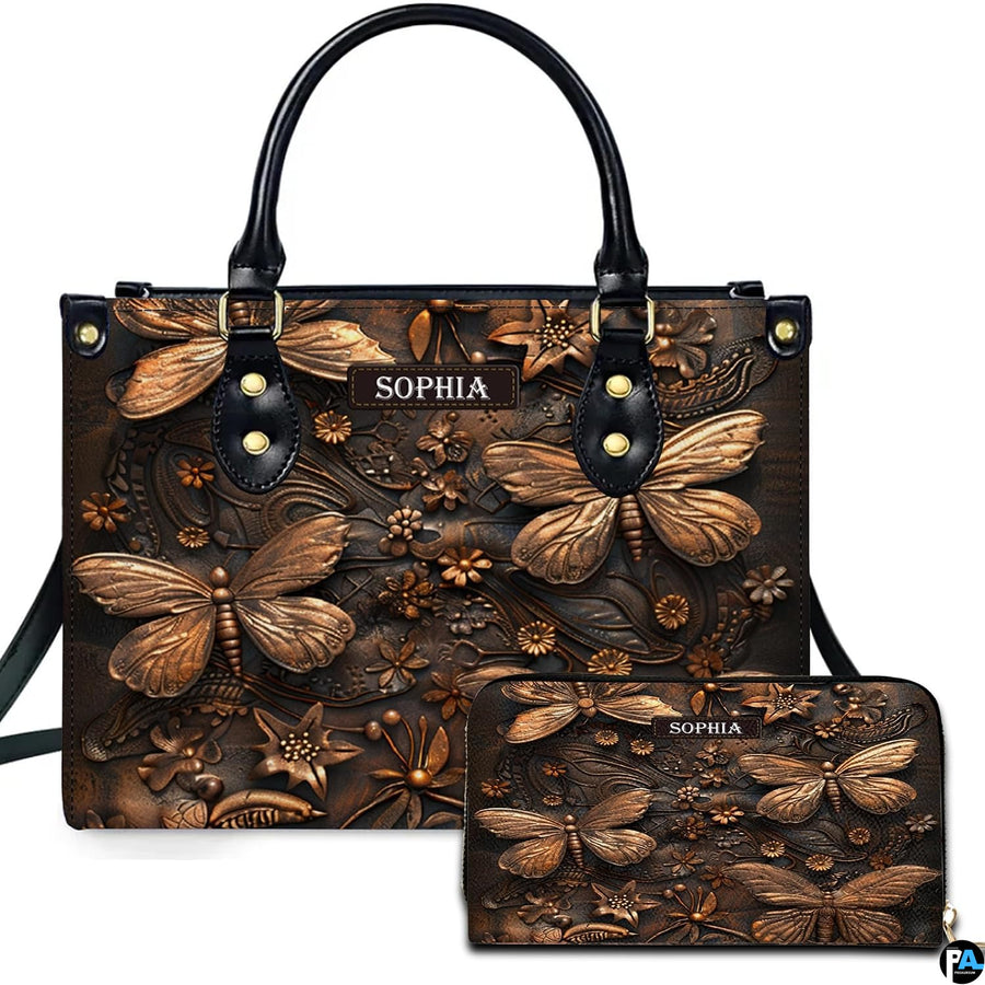 Embossed bronze dragonfly handbag and matching wallet set shown against a plain white studio background.