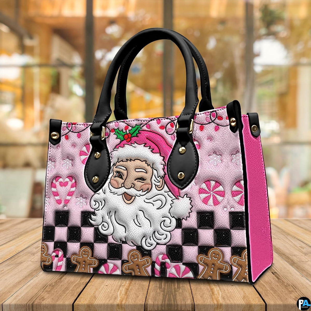Perspective view of pink Santa handbag resting on a wooden tabletop.